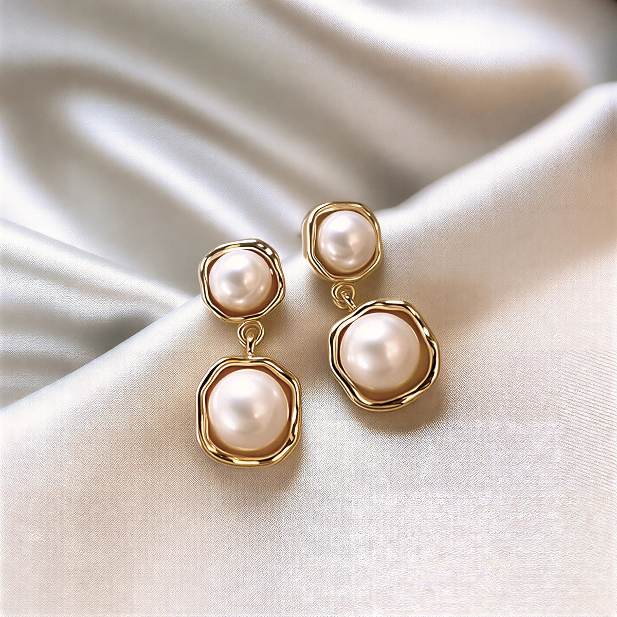 Drop-shaped pearl earrings with gold rim